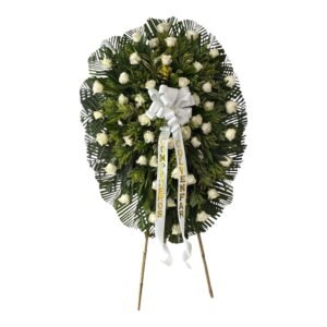 Ramo fúnebre de rosas frescas con palma, follaje verde y tarjeta en Cali