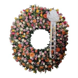 Corona fúnebre de lujo con variedad de colores de rosas, canción de la India, perla y cinta en Cali