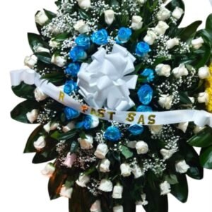 Corona fúnebre para hombre con rosas frescas y rosas pintadas en azul con follaje en Cali